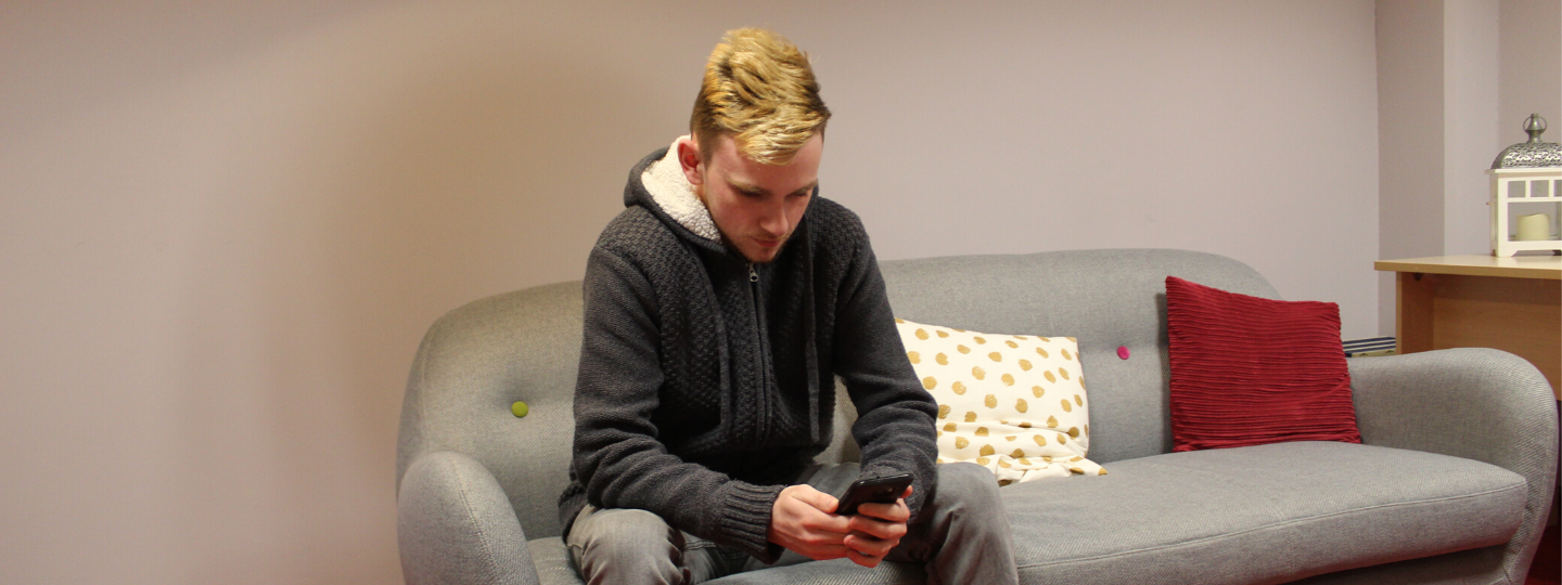 young man on a sofa on his phone