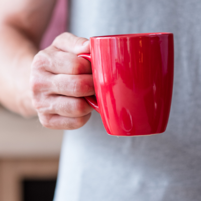 Person holding a bright red cup