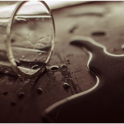 A glass knocked over with a spilled drink