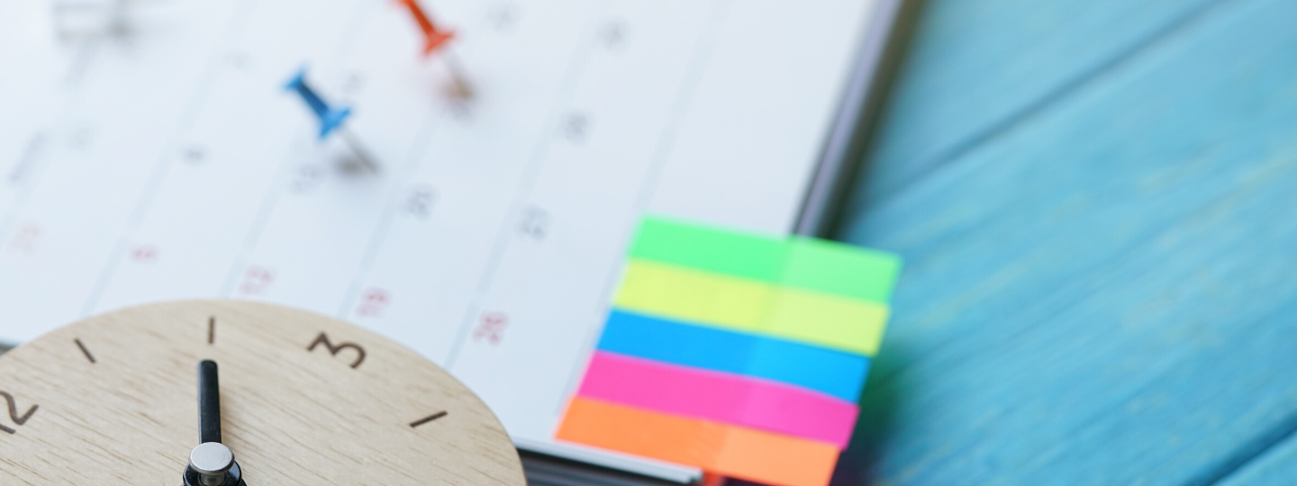 picture of a calendar with pins designating certain dates, post its notes, and a clock signifying a routine