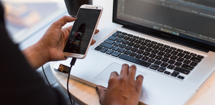 Close up of a woman using a phone on a computer