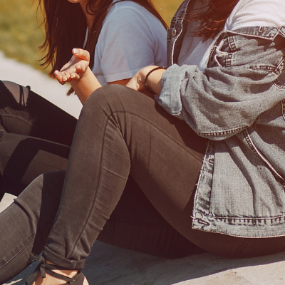 Close up of a a person comforting another, specifically a hand on their shoulder