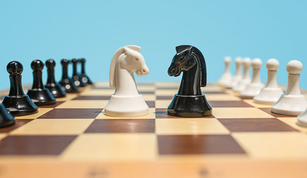 Two rooks facing off on a chess board