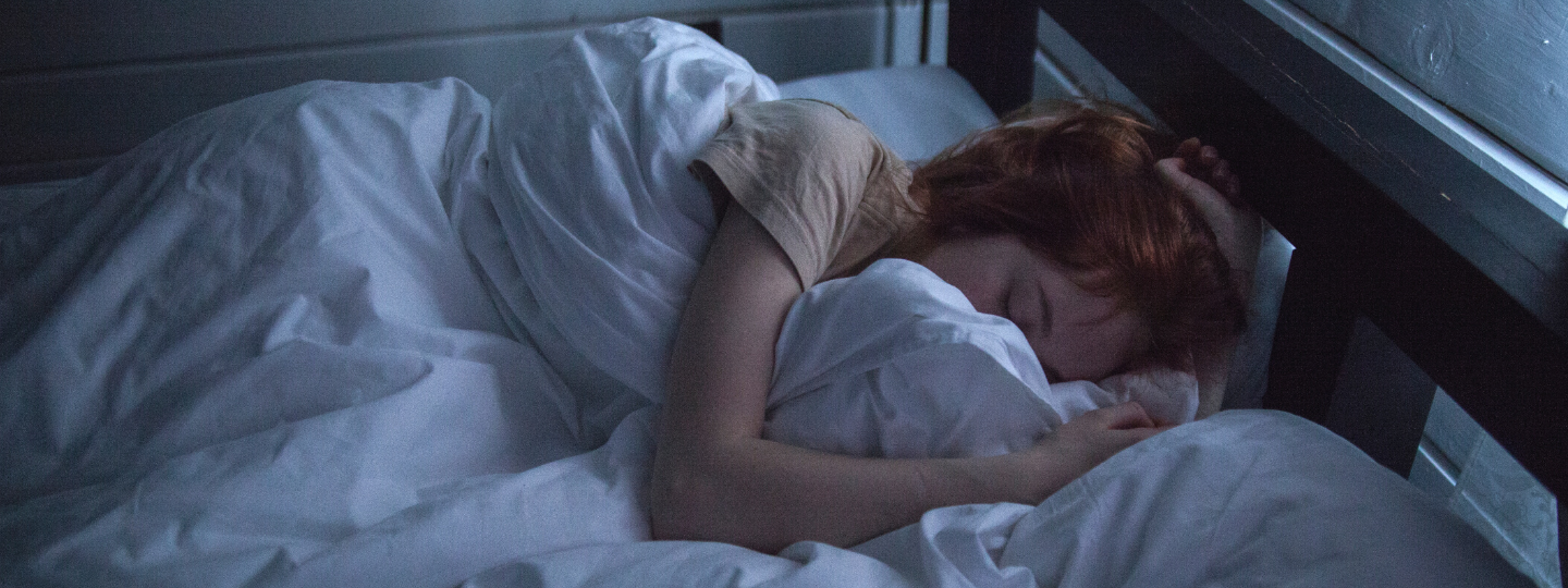 A messy room, focusing on the bed, with blankets all disogranized and junk laying around