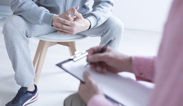 young man with counsellor taking notes