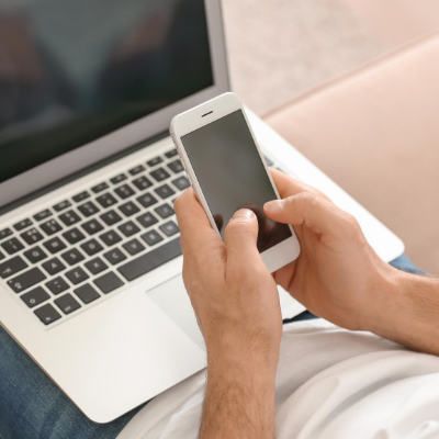 young man using phone and laptop