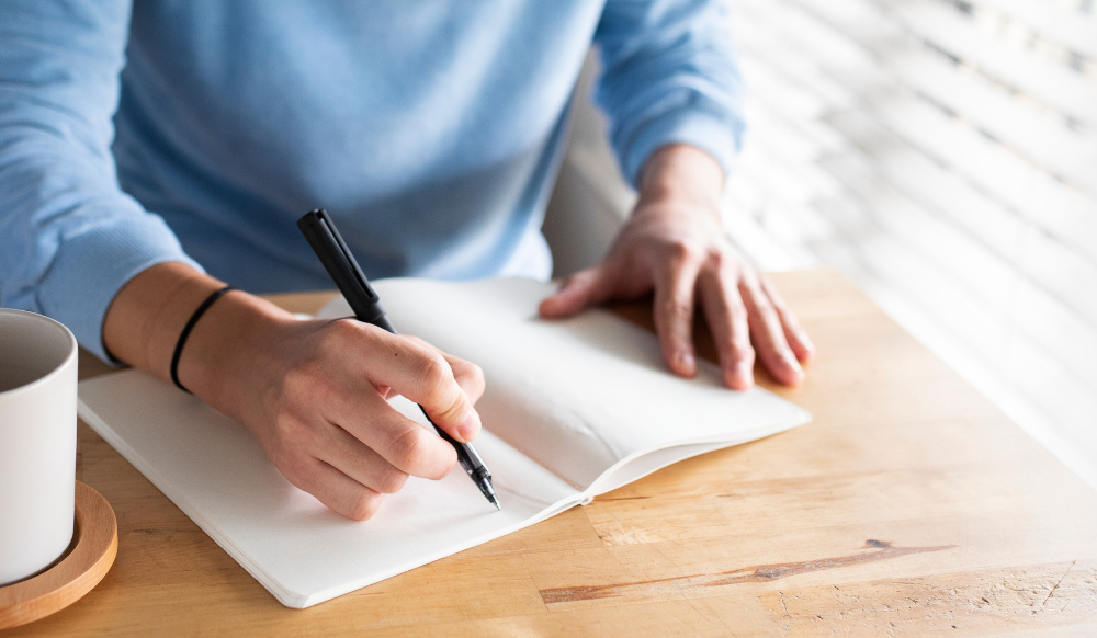 man writing in a journal