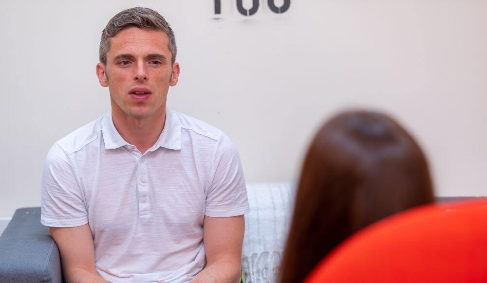 Man talking to a young woman in comfortable chairs