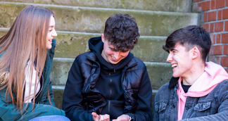 3 young people sitting and laughing