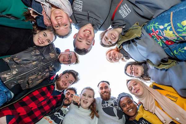 circle of young people looking down at camera