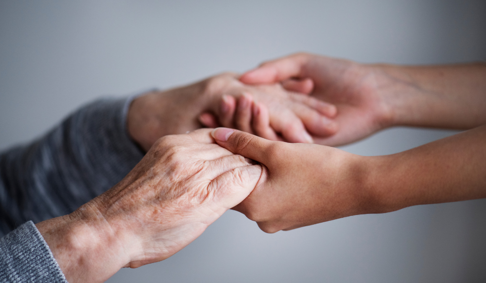 young pair of hands holding old pair of hands