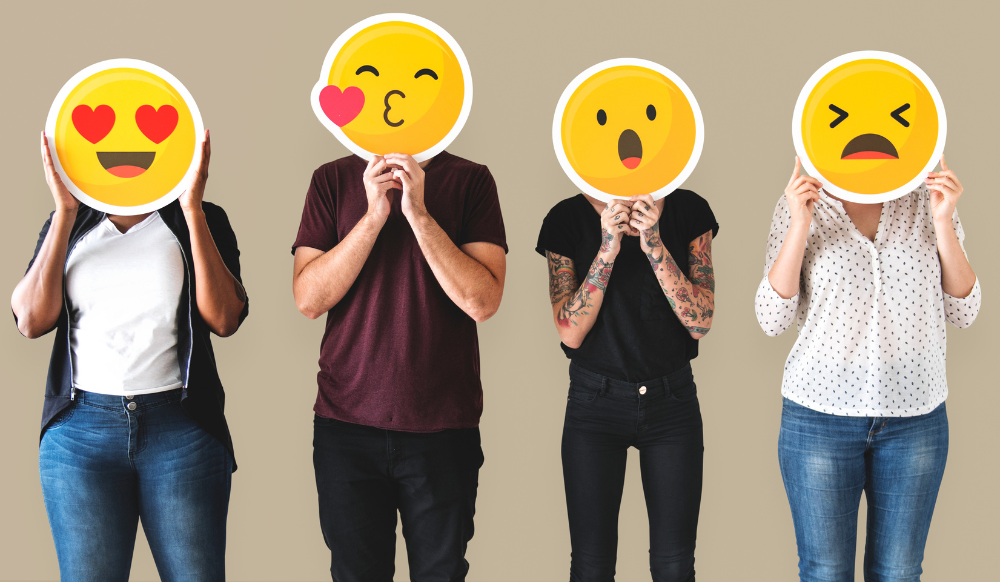 group of diverse people with different emoji cut outs in front of their faces
