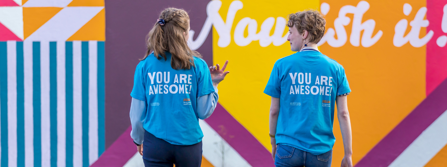 2 young people wearing you are awesome tshirts from behind