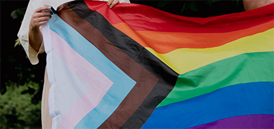 an individual holding up a pride flag