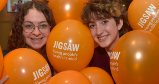 two smiling young people surrounded by balloons