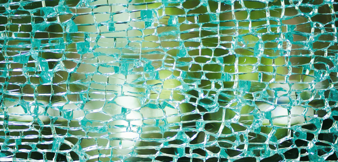 shattered mirror glass in segments held together by threads