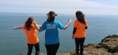 three women in jigsaw tshirts overlooking the sea