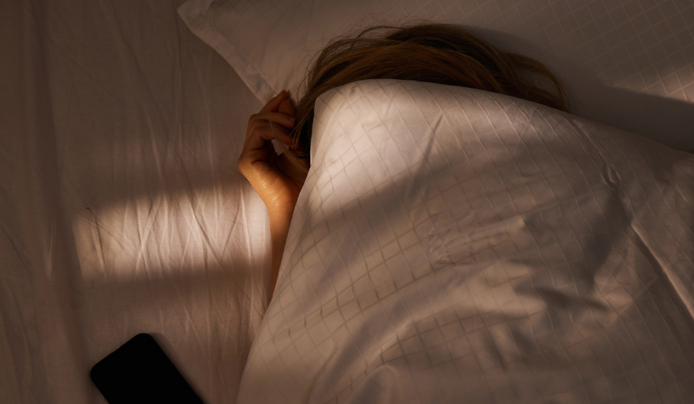 woman sleeping with covers pulled up over her head
