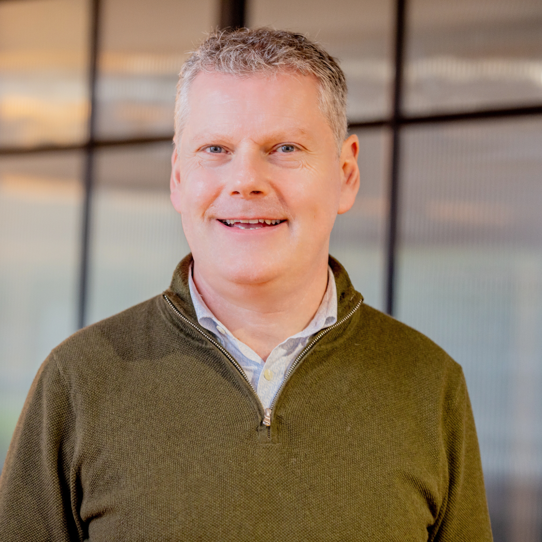 Jigsaw CEO, Dr. Joseph Duffy, wearing green jumper, smiling and looking direct to camera